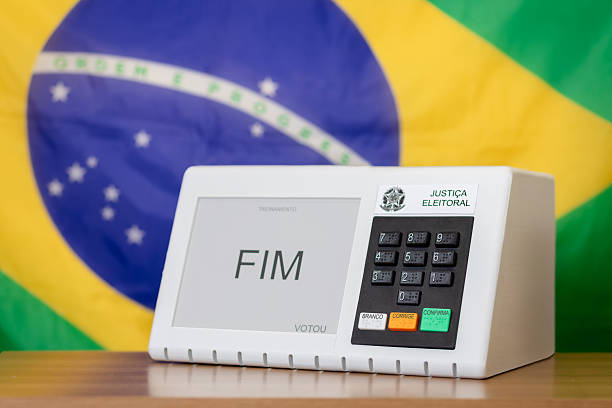 Brazilian electronic voting machine with national flag in background during presidential elections. Concept of democracy, civic participation, transparency, and electoral process in Brazil.