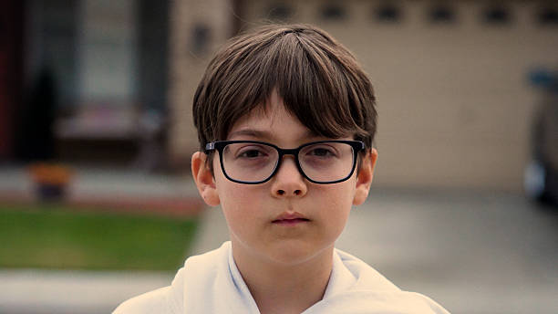 elementary schoolboy wearing eyeglasses looking at the camera