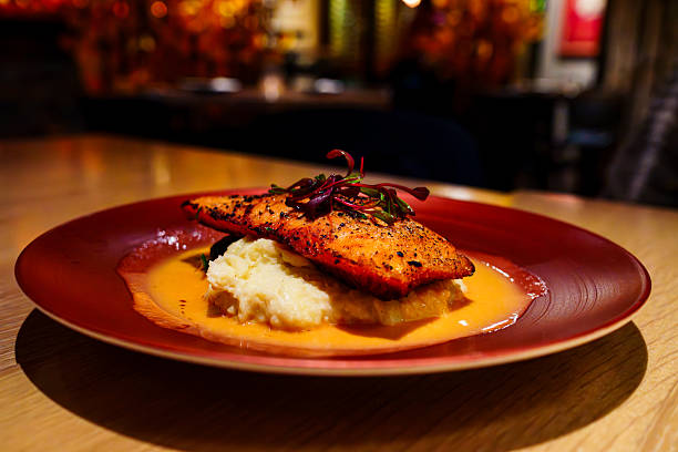 Fresh salmon served on a bed of steamed spinach and mashed potatoes.