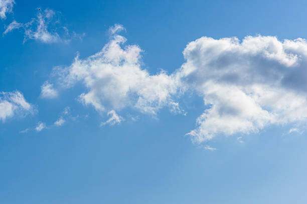 This photo was taken from the top of a hill during the winter day, capturing the clear sky and clouds shining in the sunlight.
