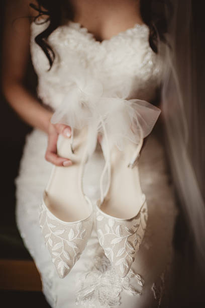 Bride in wedding dress getting ready and putting on shoes