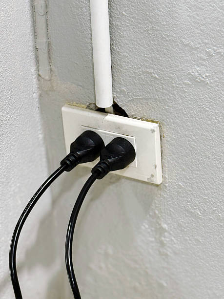 istock Electric plug and socket on white wall, closeup of photo. 2259673949