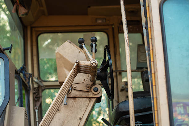 Old dirty rusty mini bulldozer digger near road over urban background with copyspace selective focus front view vertical shot