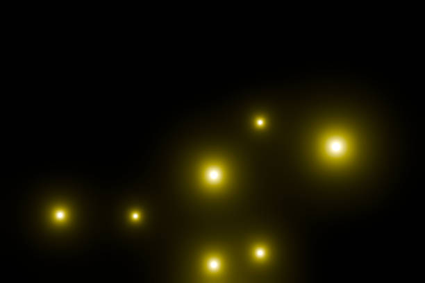 Many yellow particles floating on a black background