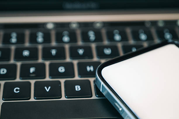 Laptop and smartphone on a white background. Close-up.