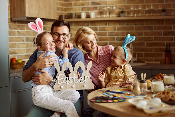 Loving father embracing his wife and kids during Easter celebration at home.
