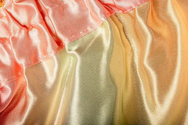 Shiny fabric texture with soft folds, abstract luxury textile background with pastel colors, elegant material surface for fashion and design concepts