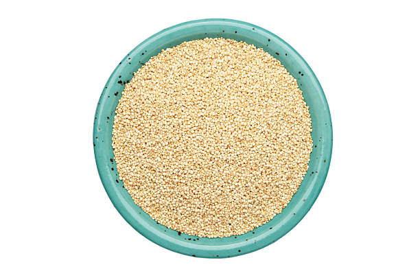 Organic white quinoa seeds in blue plate isolated on white background. Top view