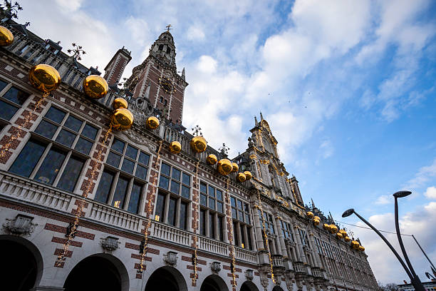 The University Library of Leuven (KU Leuven) is located on Ladeuzeplein square. The grand Neo-Flemish Renaissance building was constructed between 1921 and 1928. Gold coloured Christmas decorations are visible.
