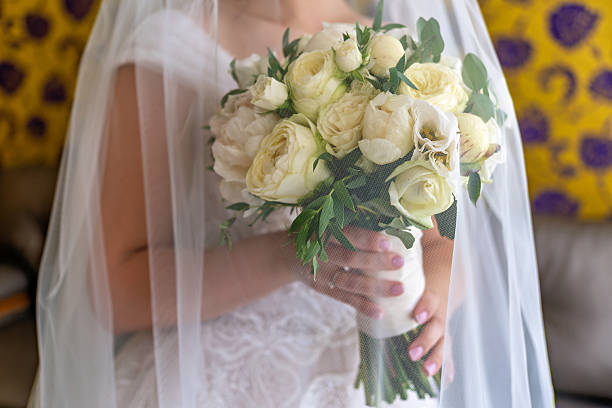 A bride holding a bouquet of white roses