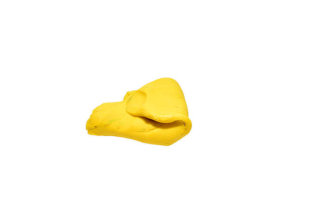 A piece of yellow plasticine isolated on a white background.