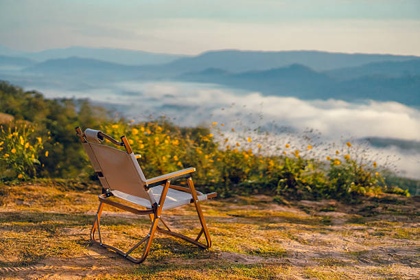 Wooden rocking chair sitting on a sunny porch overlooking green mountains