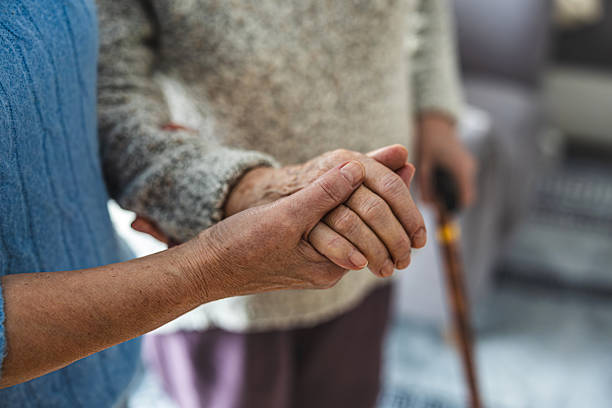 istock Senior woman with walking stick getting support from nurse, close-up 2259699674