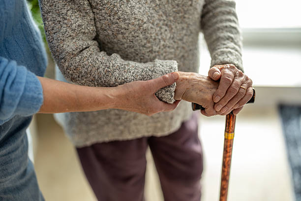istock Senior woman with walking stick getting support from nurse, close-up 2259699679