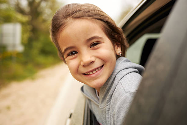 Young girl enjoying car travel with a joyful expression