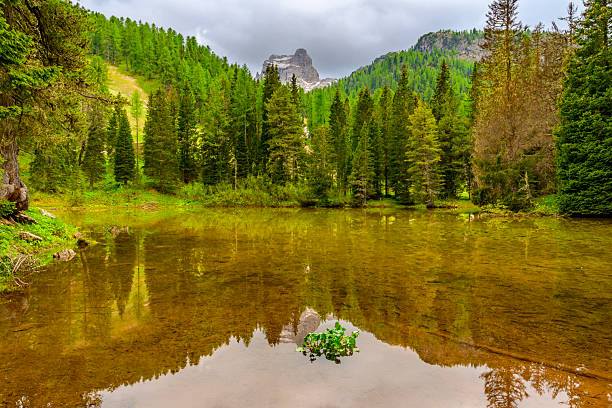 Lago bai di Dones (Lake The Woman's Bath) near the Cinque Torri (Five Towers) mountains in the Dolomites during a springtime day near Cortina D'Ampezzo in Veneto, Italy.