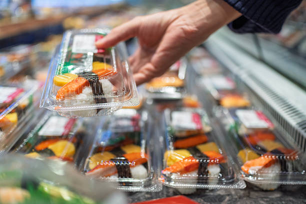 Customer Selecting Packaged Sushi from Refrigerated Display in Supermarket