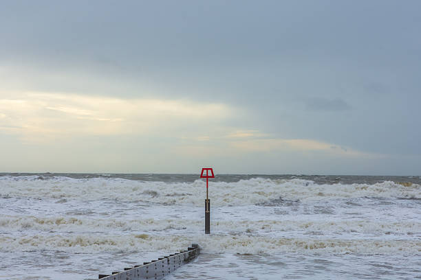 West Cliff Beach, Bournemouth, UK - January 24th 2026: Wooden beach groyne poking into rough sea.