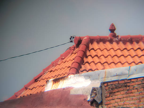A perspective view of classic orange-red clay roofing tiles on a residential building, common in Southeast Asian architecture