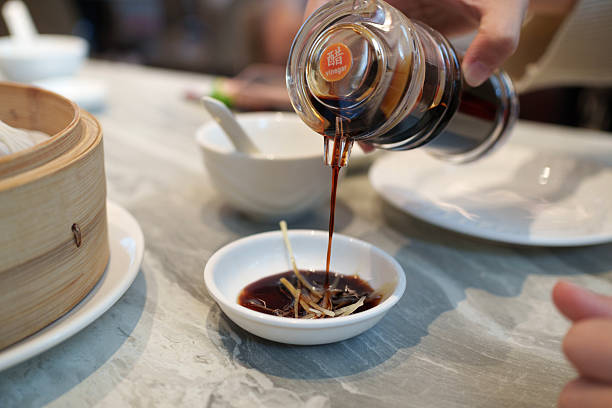 Chinese Black Vinegar Being Poured Into Dipping Sauce for Dumplings