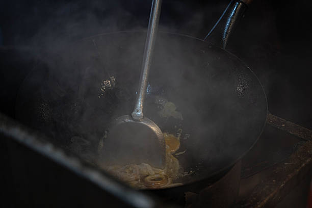 Asian street food cooking process from preparation to grilling and frying at local markets, showing authentic street cuisine without people.
