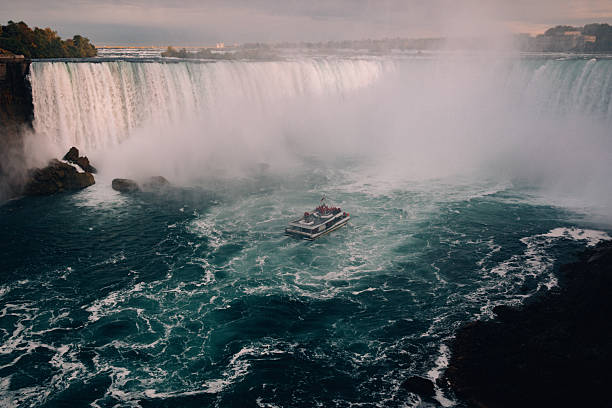 Niagara Falls, Ontario, Canada - Jun 30, 2024 : US Maid of The Mist and Canada Niagara Falls Cruise riders at the famous Niagara Falls river