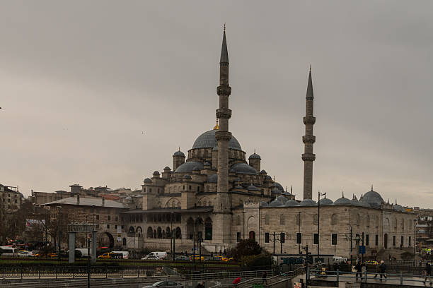 Exterior view of the Yeni Mosque located at Eminönü, overlooking the Golden Horn in Istanbul, Turkey, under overcast skies.