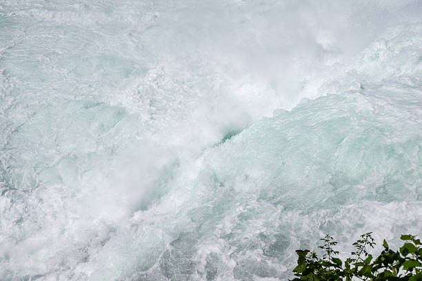 Rushing white water creating foam at europe's largest waterfall