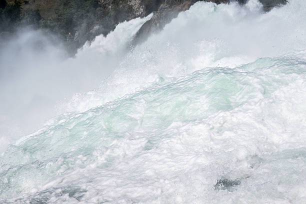 Powerful rhine falls water streaming down with great force and mist rising