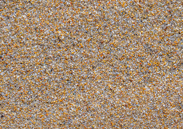 Texture of golden sand on the beach. Close-up of colorful shiny pebbles. Beautiful beach sand texture as background. space for text