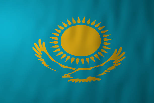 The national flag of Kazakhstan featuring a golden sun with rays and a soaring steppe eagle on a blue field. The image represents Kazakh sovereignty, national identity, and cultural heritage.