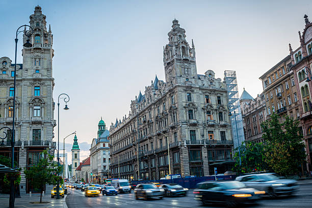 Views of historic architecture and urban life in Budapest, Hungary, featuring ornate buildings, city streets with traffic, and landmarks along the Danube River. The images include neo-Gothic and neo-Renaissance structures, religious monuments, and panoramic views of the Hungarian capital, highlighting the city’s architectural heritage and Central European character under changing daylight conditions.