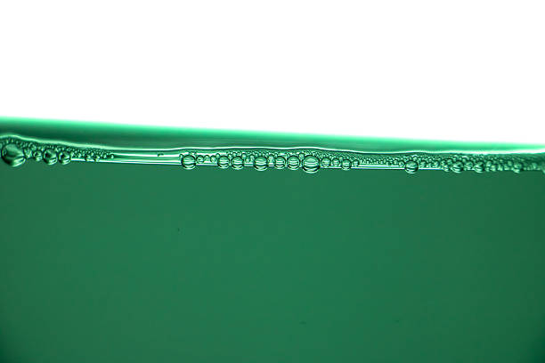 Green liquid surface with air bubbles, clean water texture, macro underwater line, freshness and purity abstract background.