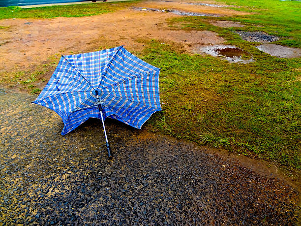 broken blue umbrella abandoned on the wet street