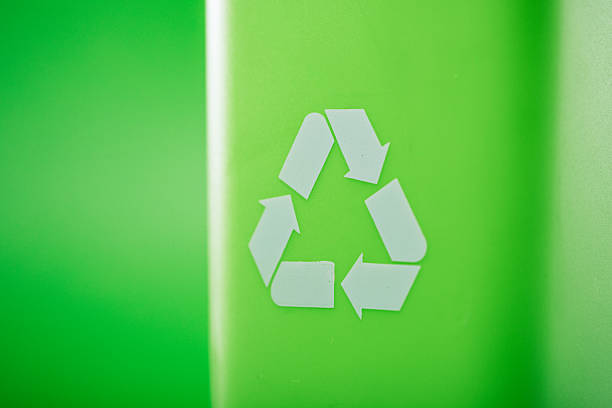 A recyclable waste rubbish bin on green studio background.  Environment friendly concept.