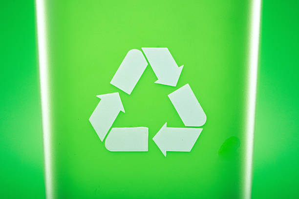 A recyclable waste rubbish bin on green studio background.  Environment friendly concept.