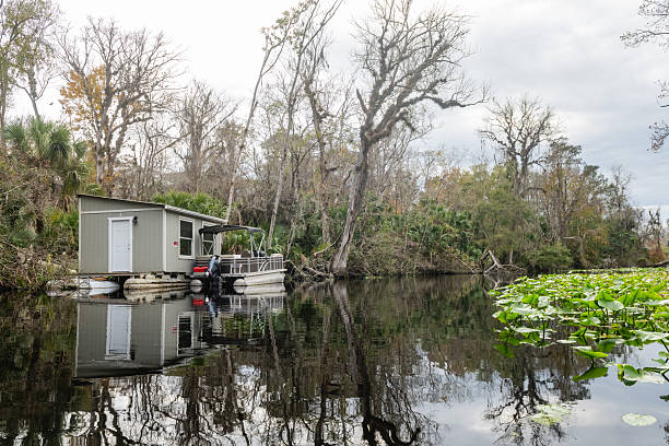 Apopka, Florida USA: December 18, 2025 - In Wekiva Springs State Park a docked pontoon boat reflects on the still water surface.