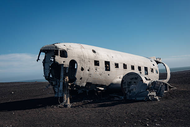U.S. Navy DC-3 plane wreck fuselage rusting on the vast black sand beach of Solheimasandur, an iconic landmark in south Iceland, with a clear blue sky