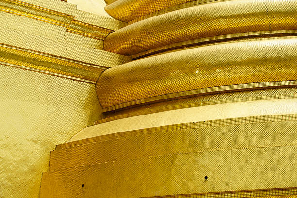 Close-up of golden architectural details featuring intricate textures and patterns, capturing the essence of luxury and artistic craftsmanship in a serene, vibrant setting.