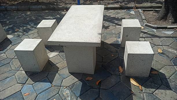 Concrete bench seating placed in a park, providing a simple resting spot for visitors while blending with the outdoor environment and supporting public comfort.