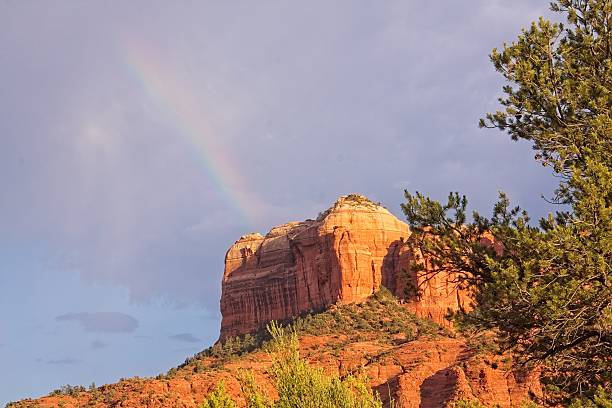 A partial rainbow by Cathedral Rock.  Sedona, Arizona. Clouds fill the sky.