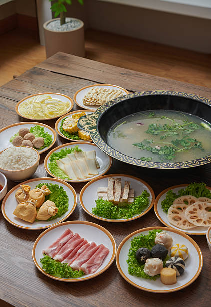 Chinese hot pot meal with assorted ingredients served on wooden table