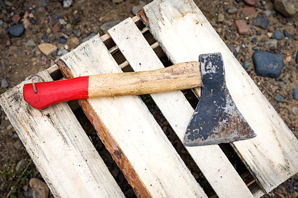An axe driven into a stump, close-up. An old axe driven into a wooden stump, blurred background. Old tool. Harvesting firewood. An axe with a wooden handle, a rotten stump, autumn. Rural life