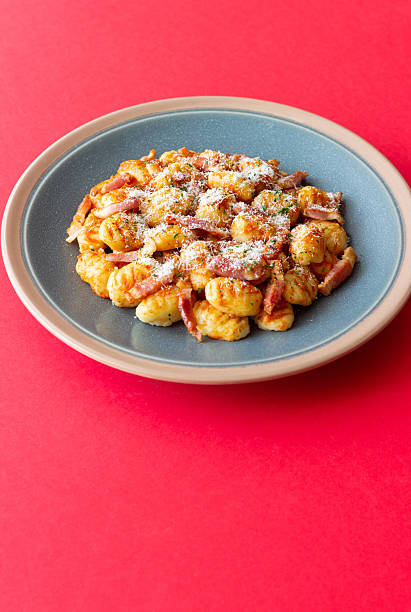 Gnocchi in tomato sauce with bacon and cheese. Italian cuisine.