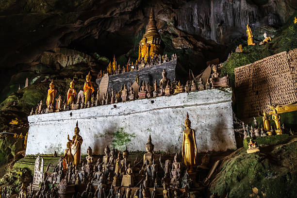 View into Laos Pak Ou Cave. Mouth of the Ou river - Tham Ting Cave inside large Mountain Rock with Buddha Statues from the 15th century. Pak Ou Cave found along the Mekong River near Luang Prabang, Laos,  Southeast Asia