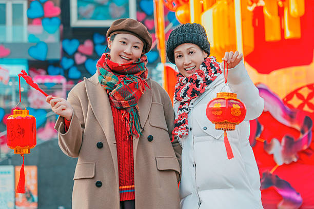 Two Women Holding Red Lanterns in Festive Setting