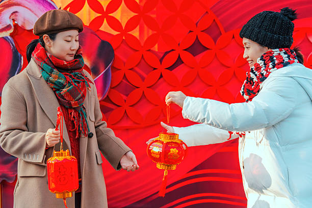 Two Women Holding Red Lanterns in Festive Setting
