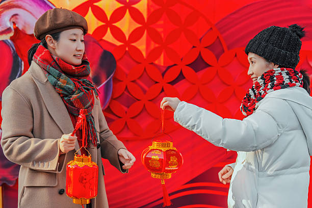 Two Women Holding Red Lanterns in Festive Setting