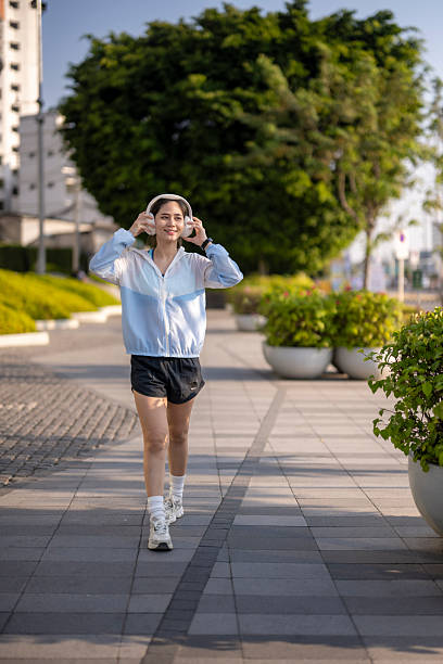 Young woman enjoying morning urban workout walking with headphones