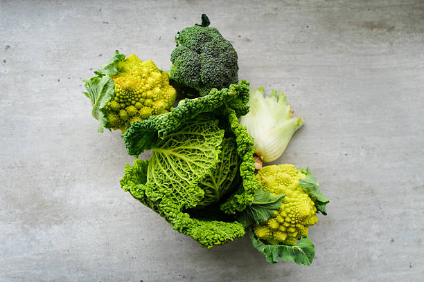 organic vegetables, brassica family, romanesco broccoli, yellow cauliflower, green broccoli, savoy cabbage, kale cabbage, fennel bulb, fresh produce, farm fresh, healthy eating, vegetarian, vegan, nutrient rich, beta carotene, superfood, market vegetables, colorful veggies, natural textures, gray background, food photography, stock photo, gourmet ingredients, plant based, dietary fiber, vitamin rich, Tuscany produce, Italian vegetables
